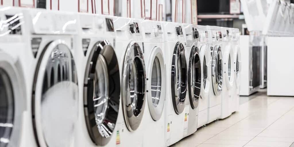 A row of washing machines in a store.